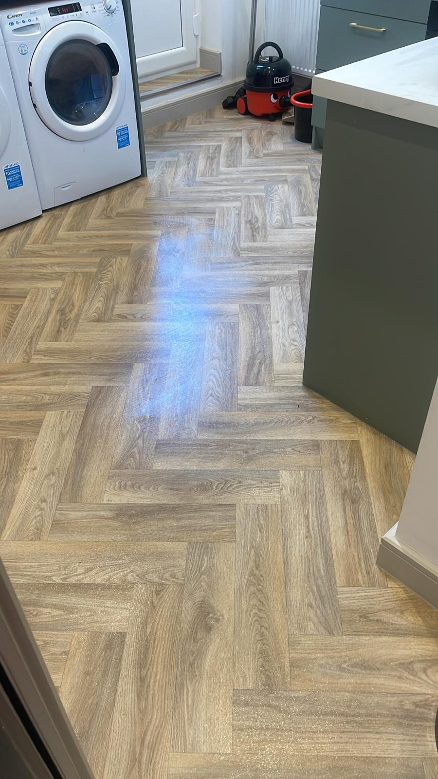 Freshly cleaned utility room with polished herringbone floors