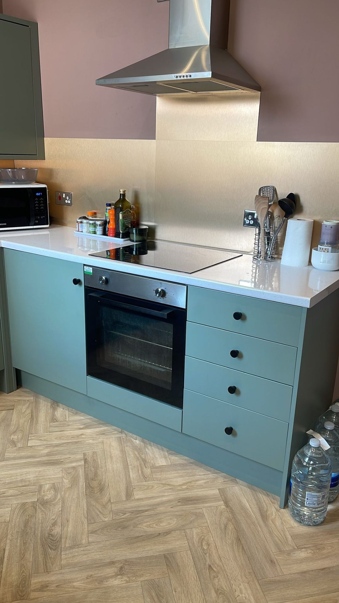 Modern kitchen with teal cabinets cleaned to a high standard